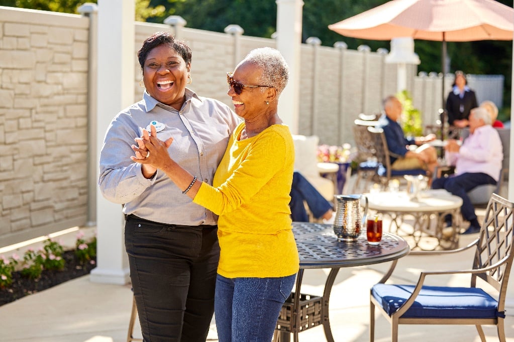 arbor terrace resident and staff dancing 